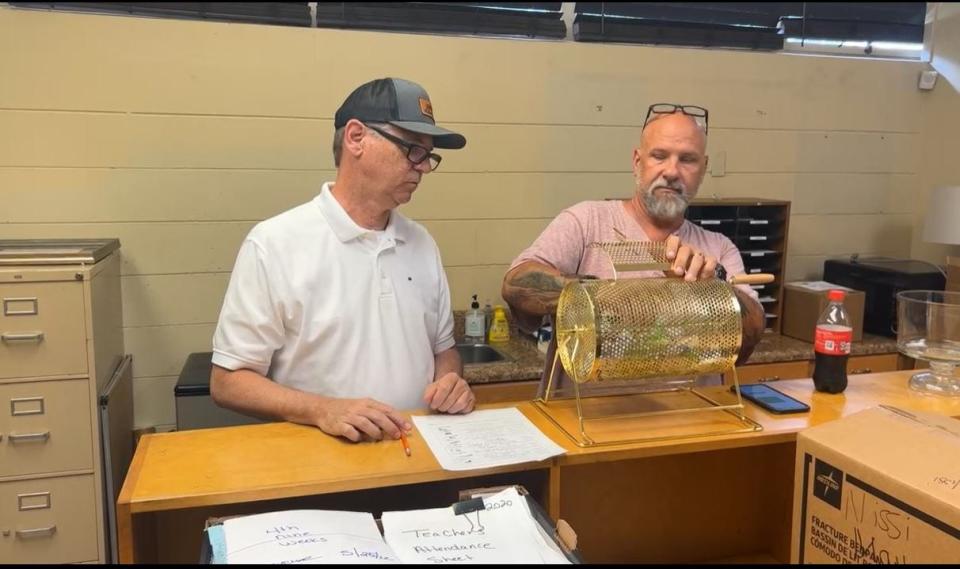 James Madison Preparatory High School assistant principal Patrick White, right, and another man raffle off handguns and rifles as part of the school's 2022 Outdoor May Madness fundraiser in a Facebook video dated May 31, 2022.