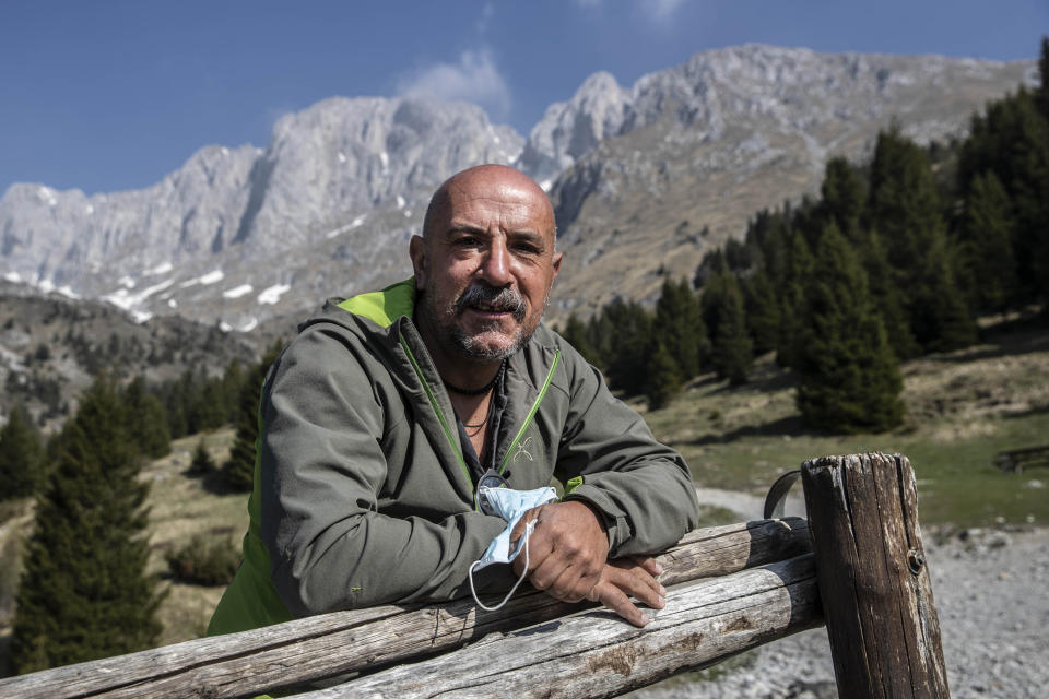 In this image take on Friday, April 24, 2020 Claudio Trentani, 57, poses for a portrait outside the shelter 'Baita Cassinelli', at 1568mt, at the foot of Mt. Presolana, seen in the background, in Castione della Presolana, near Bergamo, northern Italy. On Saturday, March 7, 2020, a day before the national lockdown was announced, he had over 100 people for lunch and was sincerely worried about the risks of infection. Now he is waiting to see if he can reopen under new laws applicable to restaurants, but with his indoor area of about 60 mq he is hoping to make the most of his outdoor space. “It is a powerful tragedy that has touched chords that not even during the war had been touched.” (AP Photo/Luca Bruno),