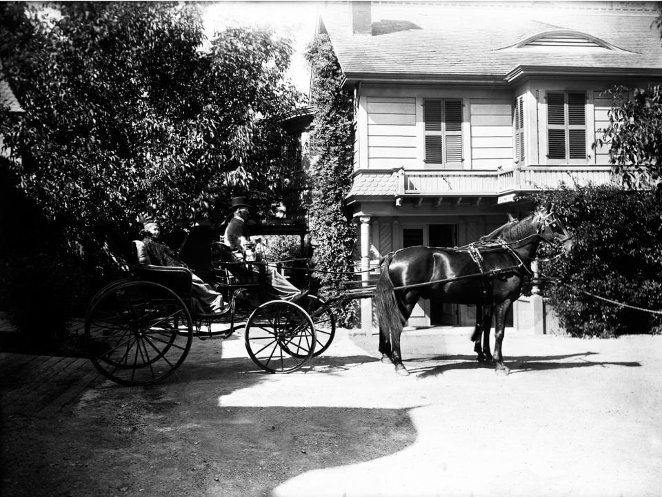 black and white photo of srah winchester in front of a farm house