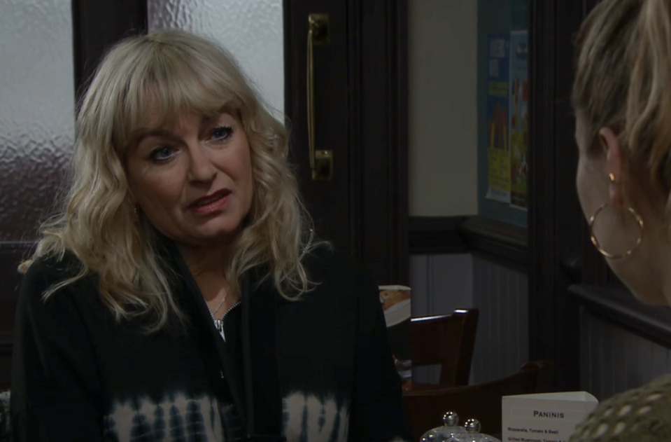 rose jackson in emmerdale, a woman sitting at a table looking at another woman in a cafe