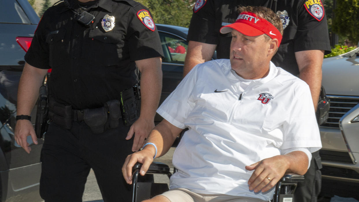 Liberty head football coach Hugh Freeze arrives to coach from a wheelchair in the coaches' box against Syracuse in an NCAA college football game in Lynchburg, Va., Saturday, Aug. 31, 2019. (AP Photo/Matt Bell)