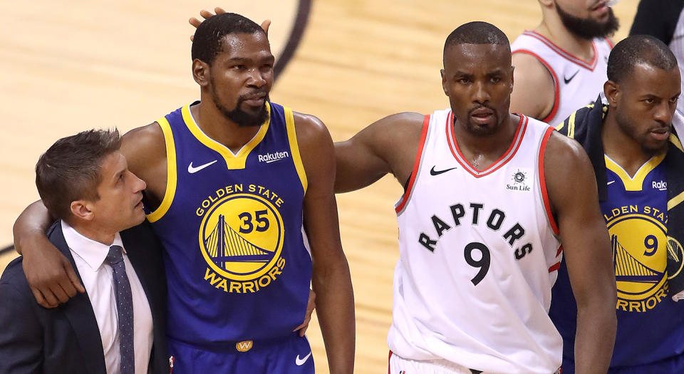 TORONTO, ONTARIO - JUNE 10:  Kevin Durant #35 of the Golden State Warriors is consoled by Serge Ibaka #9 of the Toronto Raptors after sustaining an injury in the first half during Game Five of the 2019 NBA Finals at Scotiabank Arena on June 10, 2019 in Toronto, Canada. NOTE TO USER: User expressly acknowledges and agrees that, by downloading and or using this photograph, User is consenting to the terms and conditions of the Getty Images License Agreement. (Photo by Claus Andersen/Getty Images)