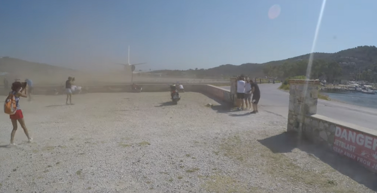 The nearest most people get to an airport runway is when they're sitting on an aircraft ready to depart.But at one Greek airport, tourists can get close enough to the runway to feel the force of a take-off.In video captured by YouTuber Cargospotter, people watching the take-off of a departing plane at Skiathos airport are seen being blown back from the force of the jet blast.As the Tui Airways aircraft gets ready for take-off, it is seen kicking up a cloud of dust in its wake.The jet blast forces tourists standing by a low wall just metres from the end of the runway to be pushed back.Later in the video, the force of a departing Air Horizont 737 aircraft almost causes a mini sandstorm.The airport on the Greek island is a popular tourist attraction, with planespotters lining up on the road behind the runway.People are warned not to get too close to the runway, with signs saying: “Danger. Please keep away from aircraft blast.”Last week, a British Airways Embraer E190 aircraft was filmed landing at Skiathos just metres above planespotters’ heads.Skiathos airport is dubbed by aviation enthusiasts “European St Maarten” due to its low landing. On the Caribbean island of St Maarten, hundreds of people gather to watch jumbo jets land just beyond a popular tourist beach.