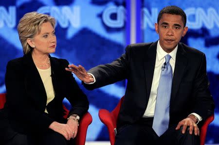 Hillary Clinton listens as Barack Obama makes a point during a debate at Saint Anselm College in Manchester, New Hampshire. REUTERS/Brian Snyder/File Photo