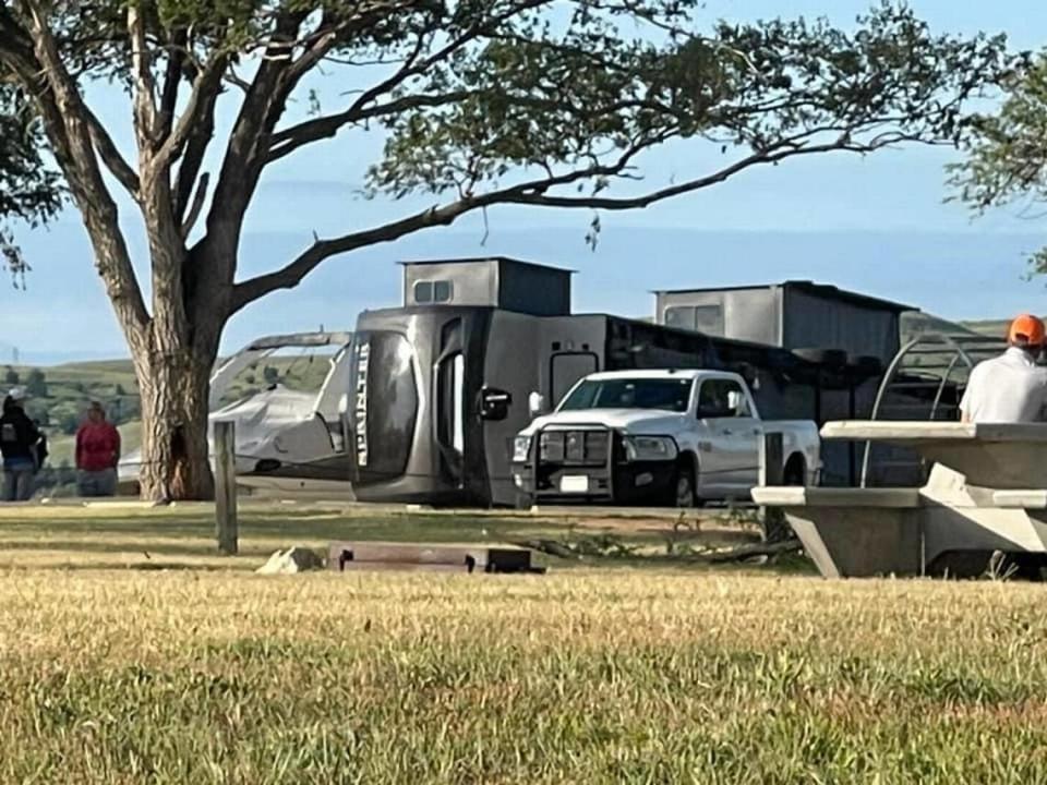 A camper sits on its side at Wilson State Park after being knocked over by strong winds gusts. Authorities found multiple other campers flipped over.