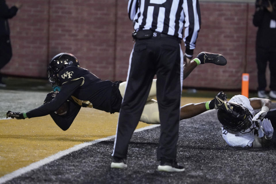 Wake Forest's A.T. Perry (9) falls out of the end zone after making a touchdown catch against Army during the second half of an NCAA college football game in Winston-Salem, N.C., Saturday, Oct. 8, 2022. (AP Photo/Chuck Burton)