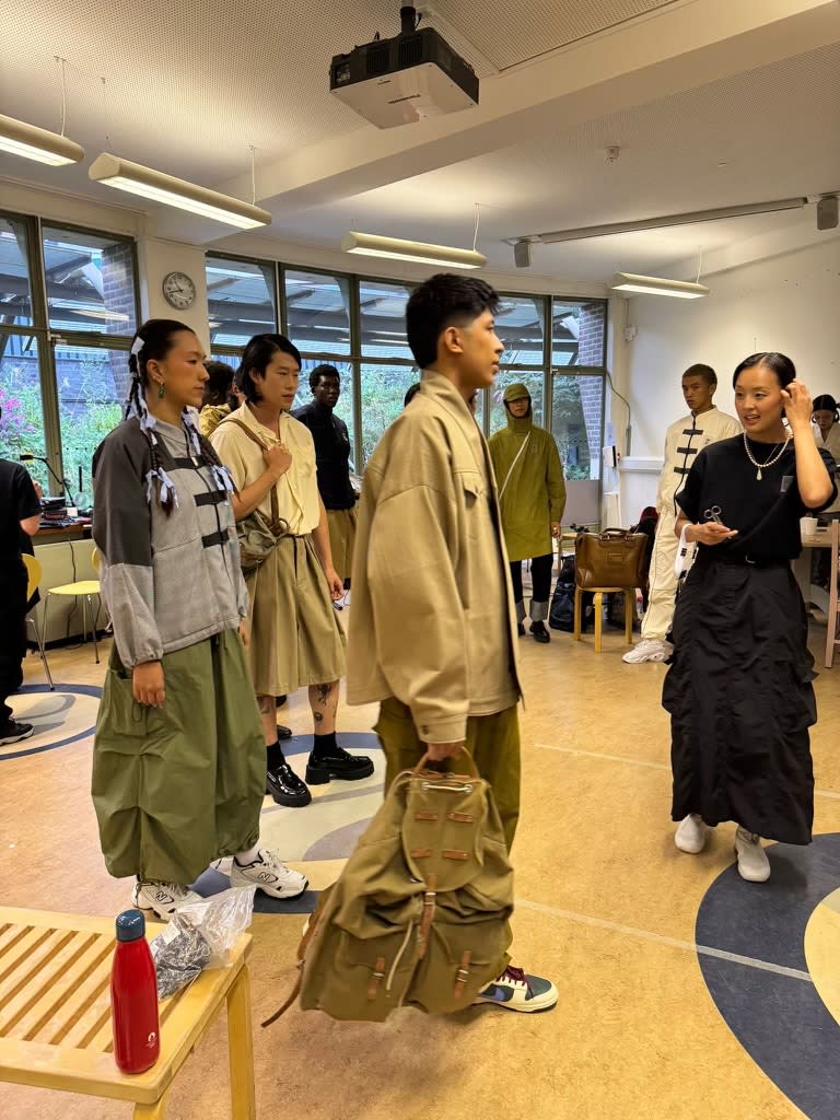 Fashion designer backstage with a room full of models