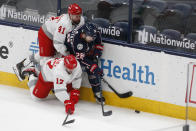 Detroit Red Wings' Luke Glendening, left, and Filip Hronek, front, fight for the puck against Columbus Blue Jackets' Oliver Bjorkstrand during the second period of an NHL hockey game Tuesday, March 2, 2021, in Columbus, Ohio. (AP Photo/Jay LaPrete)