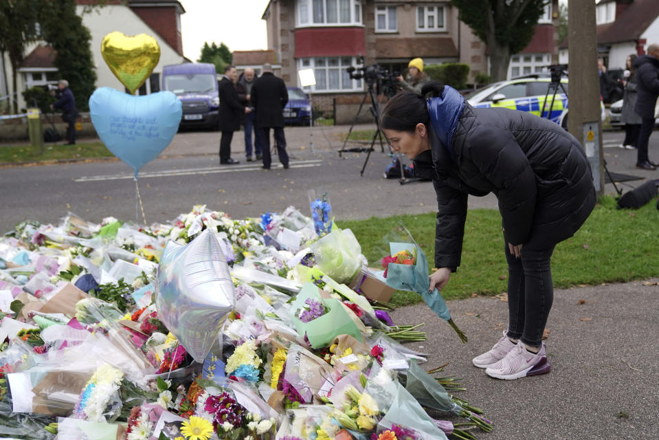 A woman places flowers near the Belfairs Methodist Church in Eastwood Road North, where member of Parliament David Amess died after he was stabbed several times on Friday, in Leigh-on-Sea, Essex, England, Sunday, Oct. 17, 2021. The slaying Friday of the 69-year-old Conservative lawmaker Amess during his regular weekly meeting with local voters has caused shock and anxiety across Britain's political spectrum, just five years after Labour Party lawmaker Jo Cox was murdered by a far-right extremist in her small-town constituency. (Kirsty O'Connor/PA via AP)