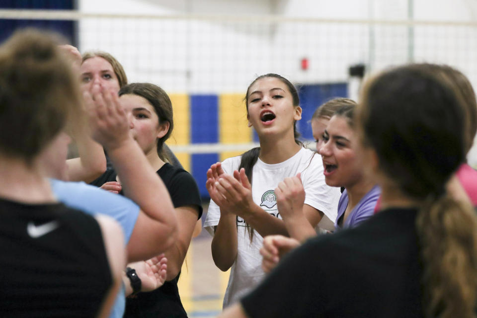 Najiah Knight, center, cheers with teammates to end a volleyball practice at Arlington High School in Arlington, Ore., Wednesday, Oct. 18, 2023. (AP Photo/Amanda Loman)