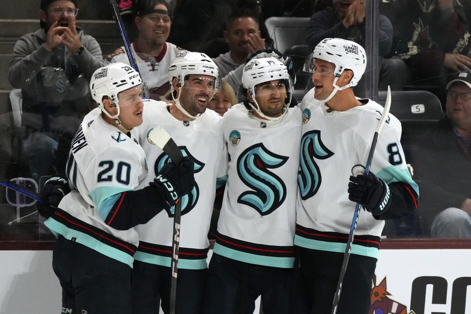 Seattle Kraken defenseman Justin Schultz (4) celebrates his goal against the Arizona Coyotes with Seattle Kraken right wing Eeli Tolvanen (20), center Matty Beniers (10) and defenseman Brian Dumoulin (8) during the second period of an NHL hockey game Tuesday, Nov. 7, 2023, in Tempe, Ariz. (AP Photo/Ross D. Franklin)