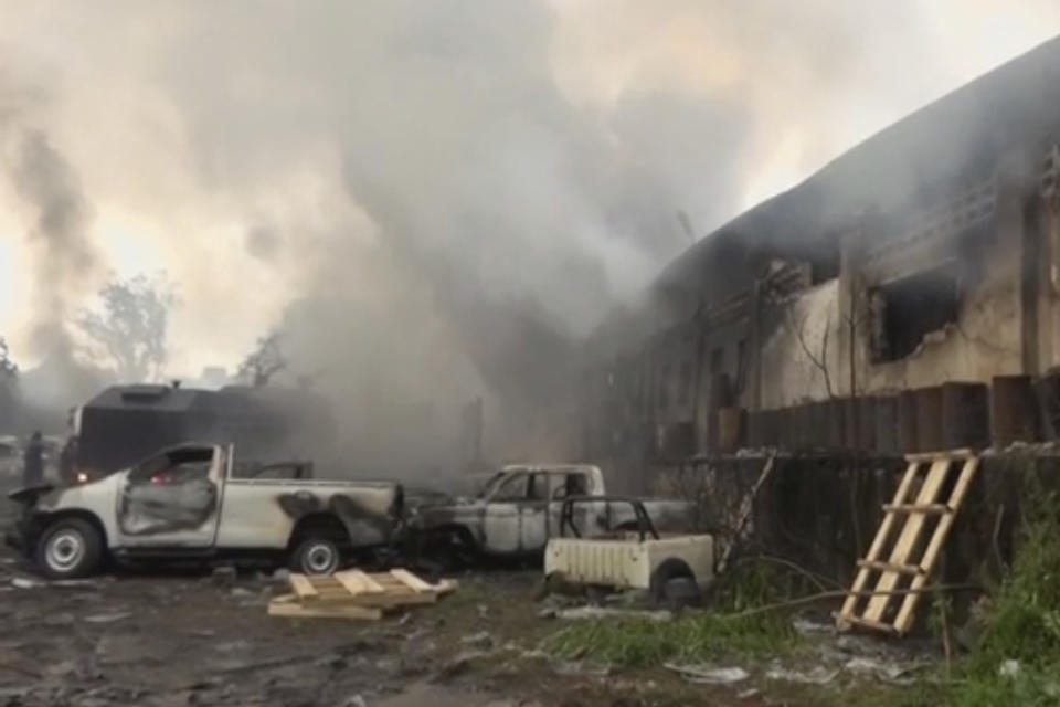 In this image from video, smoke envelopes a building as emergency services attend an early-morning fire in Congo's capital Kinshasa, Thursday Dec. 13, 2018, which is reported to have destroyed thousands of voting machines just 10-days before the upcoming presidential election. Officials said Thursday, the blaze appeared to be criminal in nature but vowed that it would not disrupt the Dec. 23, vote. (AP Photo)