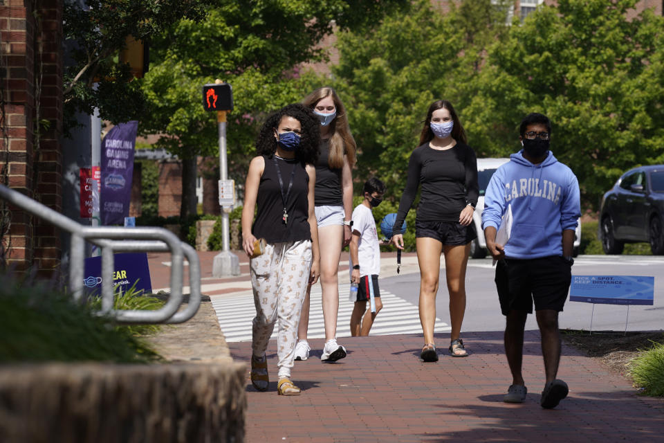 FILE - In this Aug. 18, 2020, file photo, students wear masks on campus at the University of North Carolina in Chapel Hill, N.C. As more and more schools and businesses around the country get the OK to reopen, some college towns are moving in the opposite direction because of too much partying and too many COVID-19 infections among students. (AP Photo/Gerry Broome, File)