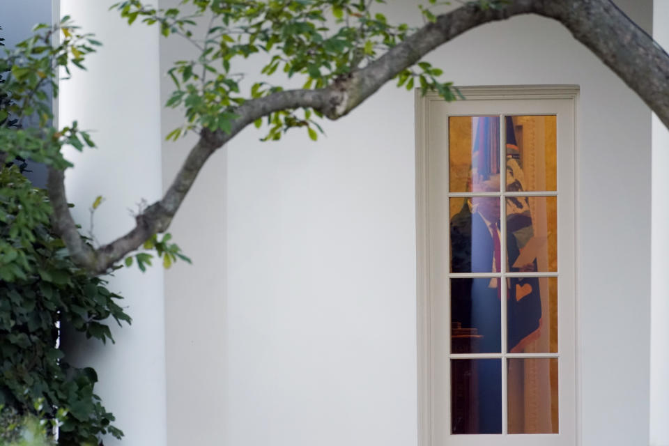 President Donald Trump waves to members of the press from the Oval Office at the White House in Washington, Tuesday, Oct. 20, 2020. (AP Photo/Andrew Harnik)