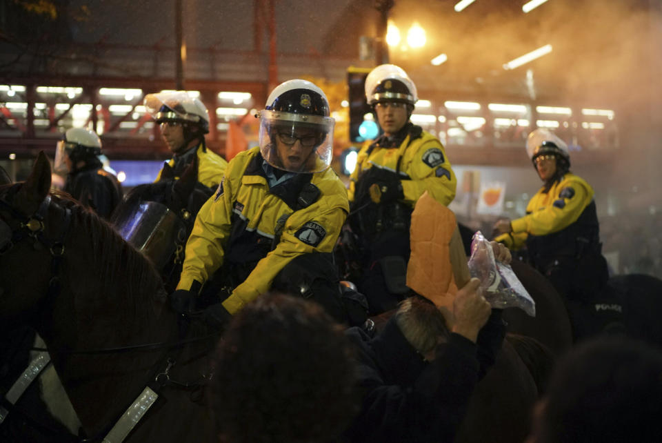 Minneapolis police on horseback ride through a group of protesters outside the Target Center, Thursday, Oct. 10, 2019, in Minneapolis. Protesters got into a brief confrontation with police outside President Donald Trump's campaign rally in Minneapolis after some of the demonstrators set Trump hats on fire. (Jeff Wheller/Star Tribune via AP)