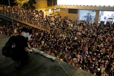 Protesters hang a banner as they siege police headquarters after a rally ahead of the G20 summit in Hong Kong