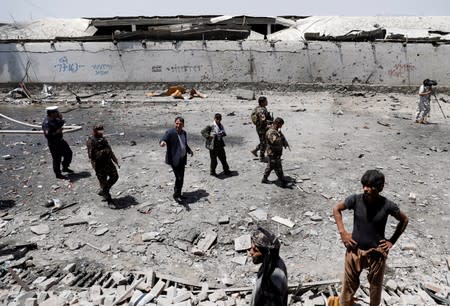 Afghan security forces inspect the site of a blast in Kabul, Afghanistan