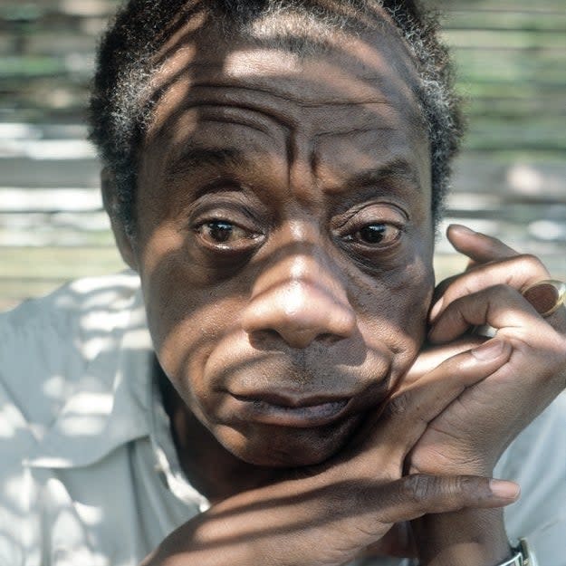 Close-up of James Baldwin with a pensive expression, resting his cheek on his hand