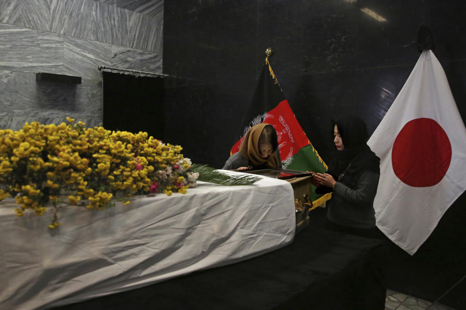 From left, the wife and daughter of slain Japanese physician Tetsu Nakamura stand next to his coffin after they arrived to pay their tribute to Nakamura at the Afghan military hospital in Kabul, Afghanistan, Friday, Dec. 6, 2019. (AP Photo/Tamana Sarwary)