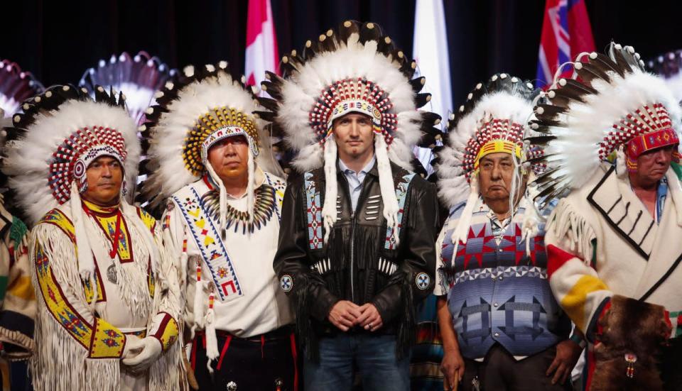 Prime Minister Justin Trudeau, centre, poses with elders after receiving a ceremonial headdress while visiting the Tsuu T'ina First Nation near Calgary, Alta., Friday, March 4, 2016. THE CANADIAN PRESS/Jeff McIntosh