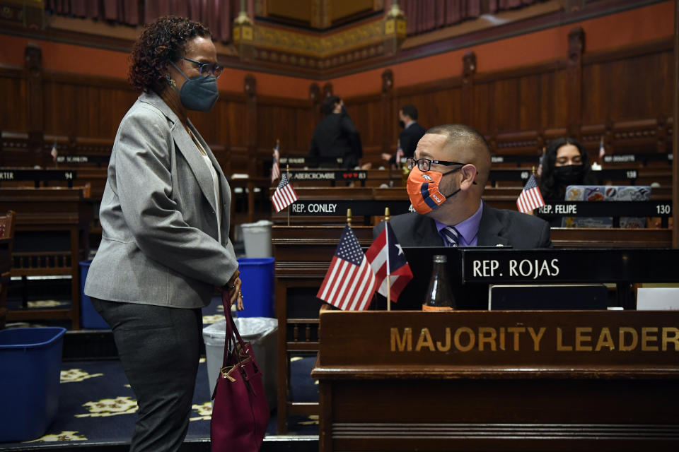 Connecticut House Majority Leader Jason Rojas, D-East Hartford, right, speaks with State Rep. Toni Walker, D-New Haven, left, during session at the State Capitol in Hartford, Conn., on Monday, April 19, 2021. In July 2020 after George Floyd was killed in Minneapolis, Black and Latino members of the Connecticut General Assembly worked to enact sweeping changes to policing in the state, and since, have continue to flex their collective muscles. (AP Photo/Jessica Hill)