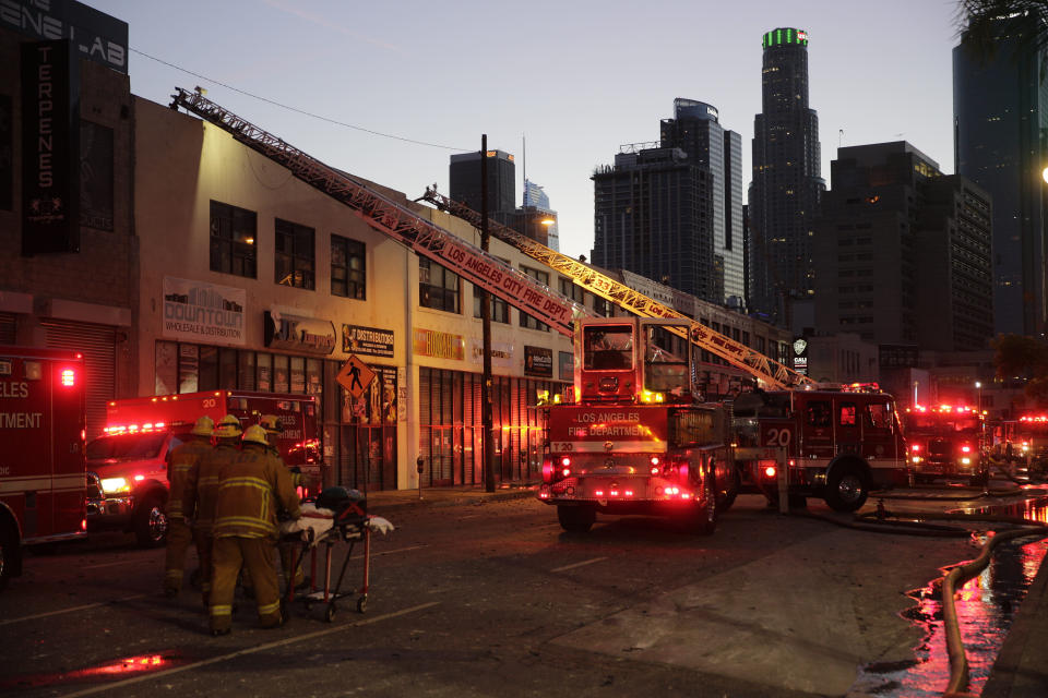 Los Angeles Fire Department firefighters work the scene of a structure fire that injured multiple firefighters, according to a fire department spokesman, Saturday, May 16, 2020, in Los Angeles. (AP Photo/Damian Dovarganes)