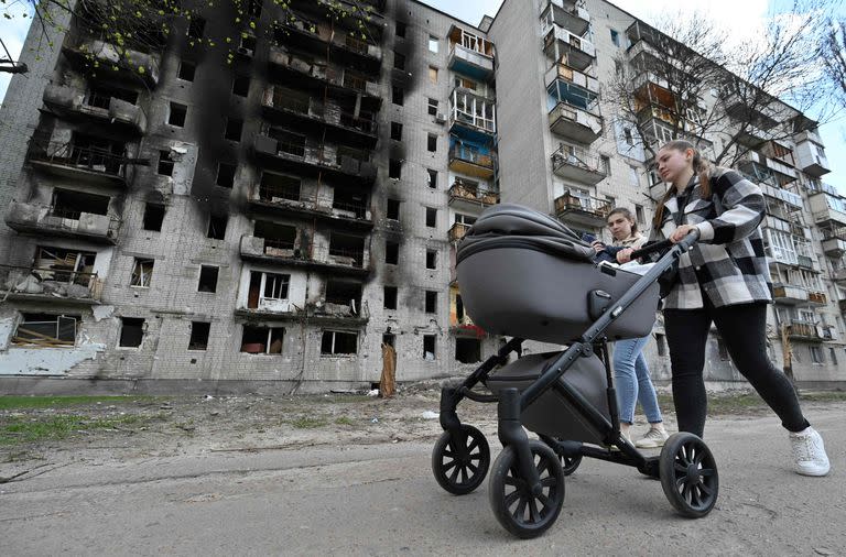 Una mujer pasa junto a un edificio severamente dañado en Chernihiv