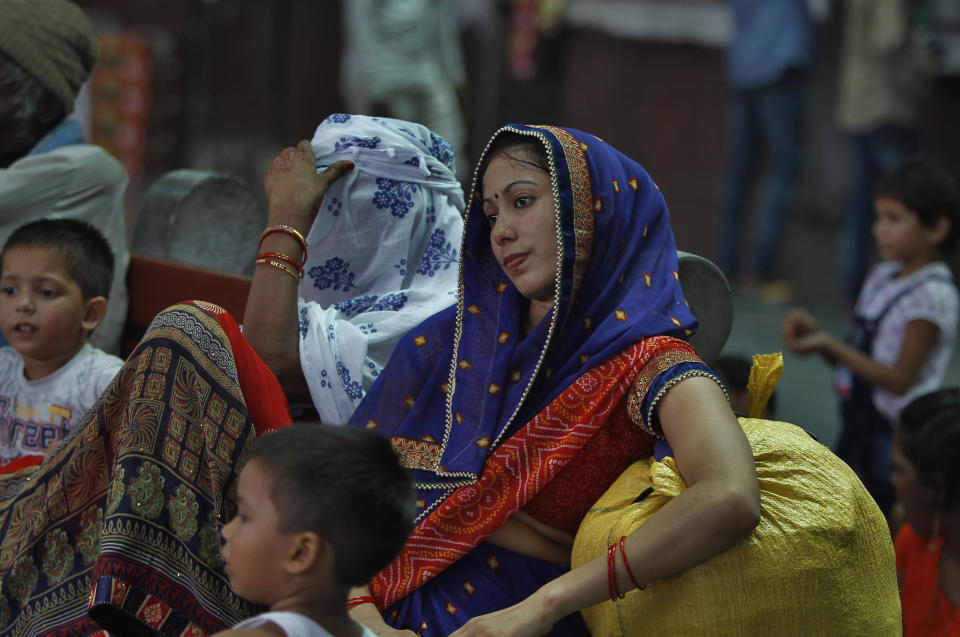 Women tourists with their children wait for train at a railway station in Jammu, India, Sunday, Aug. 4, 2019. Thousands of Indian students and visitors were fleeing Indian-controlled Kashmir over the weekend after the government ordered tourists and Hindu pilgrims visiting a Himalayan cave shrine "to curtail their stay" in the disputed territory, citing security concerns. (AP Photo/Channi Anand)