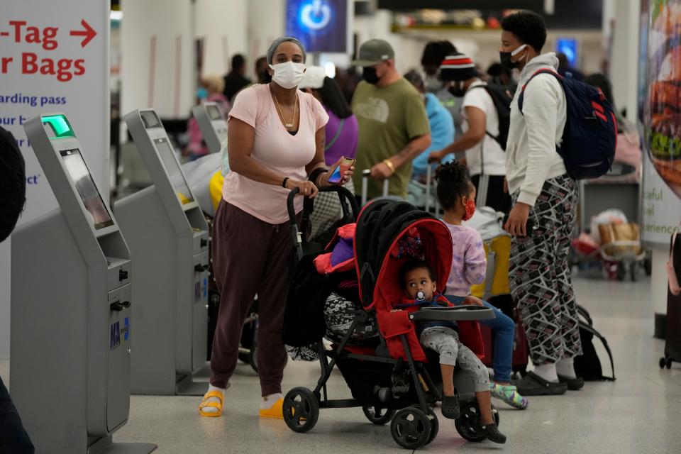 Travelers use kiosks to check in for flights at Miami International Airport amid airline staffing shortages due to the rapid spread of the omicron COVID-19 variant in the United States.