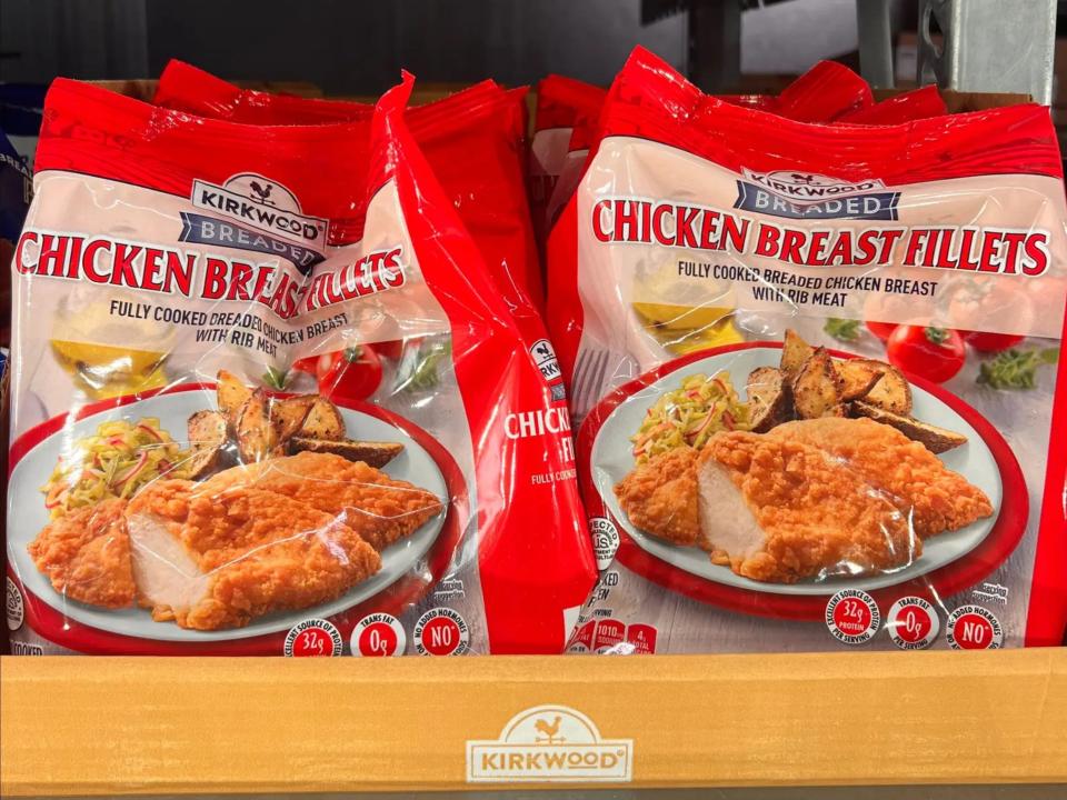Red bags of Kirkwood breaded chicken breast fillets on a shelf at Aldi