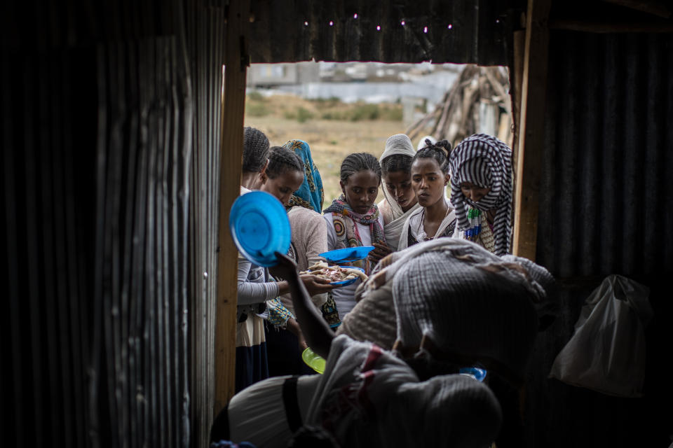 Tigrayans stand in line to receive food donated by local residents at a reception center for the internally displaced in Mekele, in the Tigray region of northern Ethiopia, on Sunday, May 9, 2021. (AP Photo/Ben Curtis)