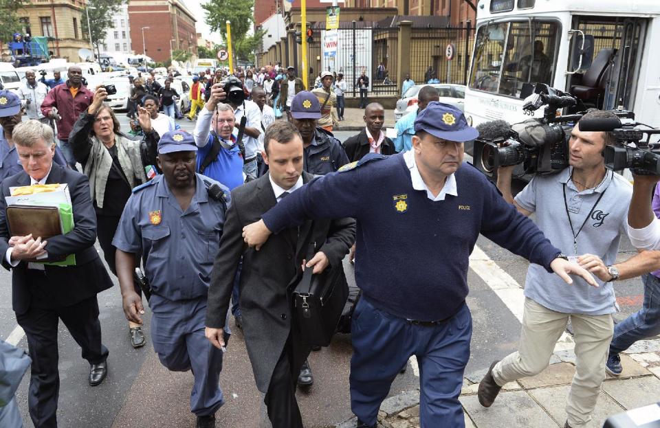 Oscar Pistorius, center, is escorted outside court during a recess on the third day of his trial at the high court in Pretoria, South Africa, Wednesday, March 5, 2014, Pistorius is charged with murder for the shooting death of his girlfriend, Reeva Steenkamp, on Valentines Day in 2013. (AP Photo/Antoine de Ras) SOUTH AFRICA OUT