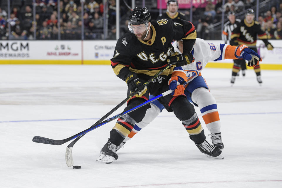 New York Islanders left wing Anders Lee (27) tries to get the puck from Vegas Golden Knights defenseman Alex Pietrangelo (7) during the second period of an NHL hockey game Saturday, Dec. 17, 2022, in Las Vegas. (AP Photo/Sam Morris)