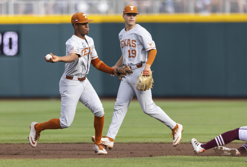 Texas' Trey Faltine (0), left, turns a double play in the second inning against Mississippi State during a baseball game in the College World Series, Saturday, June 26, 2021, at TD Ameritrade Park in Omaha, Neb. (AP Photo/Rebecca S. Gratz)