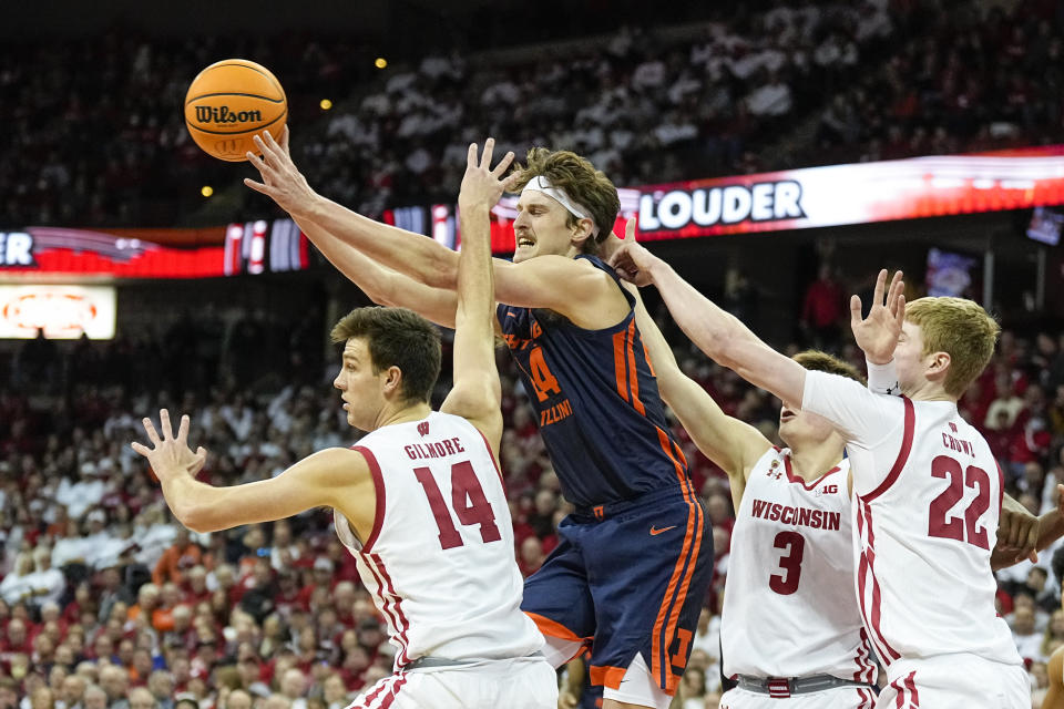 Illinois's Matthew Mayer (24) passes against Wisconsin's Carter Gilmore (14), Connor Essegian (3) and Steven Crowl, right, during the first half of an NCAA college basketball game, Saturday, Jan. 28, 2023, in Madison, Wis. (AP Photo/Andy Manis)