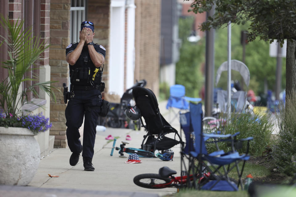 FILE - A Lake Forest, Ill., police officer walks down Central Ave in Highland Park, Ill., on Monday, July 4, 2022, after a shooter fired on the Chicago northern suburb's Fourth of July parade. Chicago is one of the nation's gun violence hotspots and a seemingly ideal place to employ Illinois' "red flag” law that allows police to step in and take firearms away from people who threaten to kill. But amid more than 8,500 shootings resulting in 1,800 deaths since 2020, the law was used there just four times. (Brian Cassella/Chicago Tribune via AP, File)