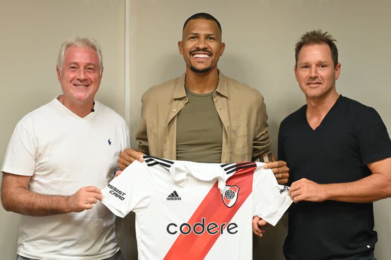 El venezolano Salomón Rondón sostiene la camiseta de River junto al presidente Jorge Brito y el vice Matías Patanian