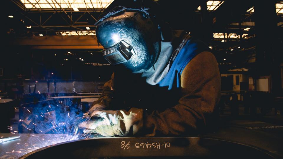 A welder works on a U.S. Navy ship at a steel production facility. (Ashley Cowan/Newport News Shipbuilding)