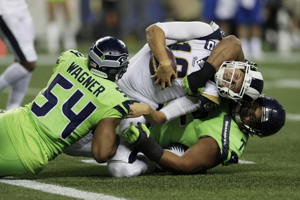 Los Angeles Rams quarterback Jared Goff, center, is tackled by Seattle Seahawks defensive tackle Al Woods, right, and middle linebacker Bobby Wagner. (AP Photo/Stephen Brashear)