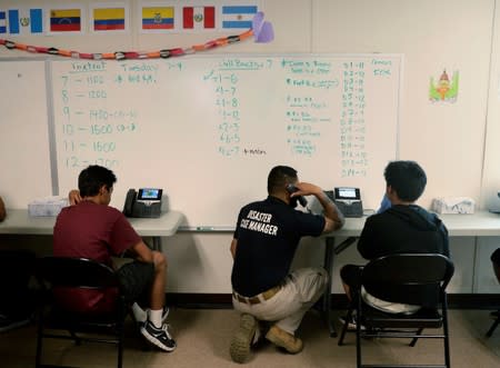 Staff help immigrants make calls to family at a call center at the U.S. government's newest holding center for migrant children in Carrizo Springs