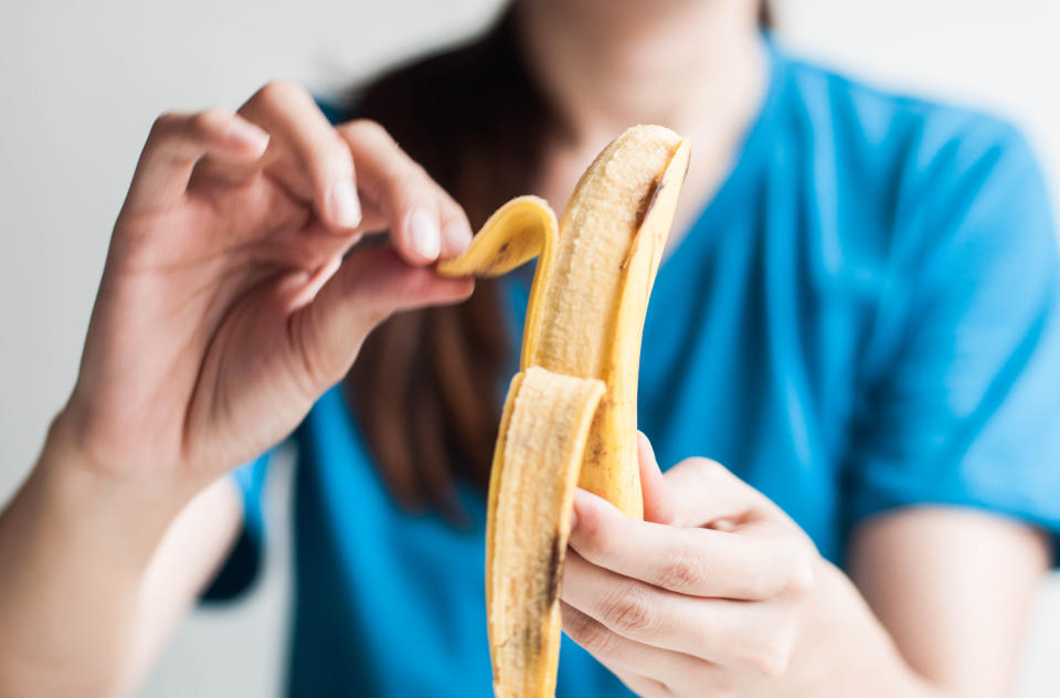 La femme épluche une banane