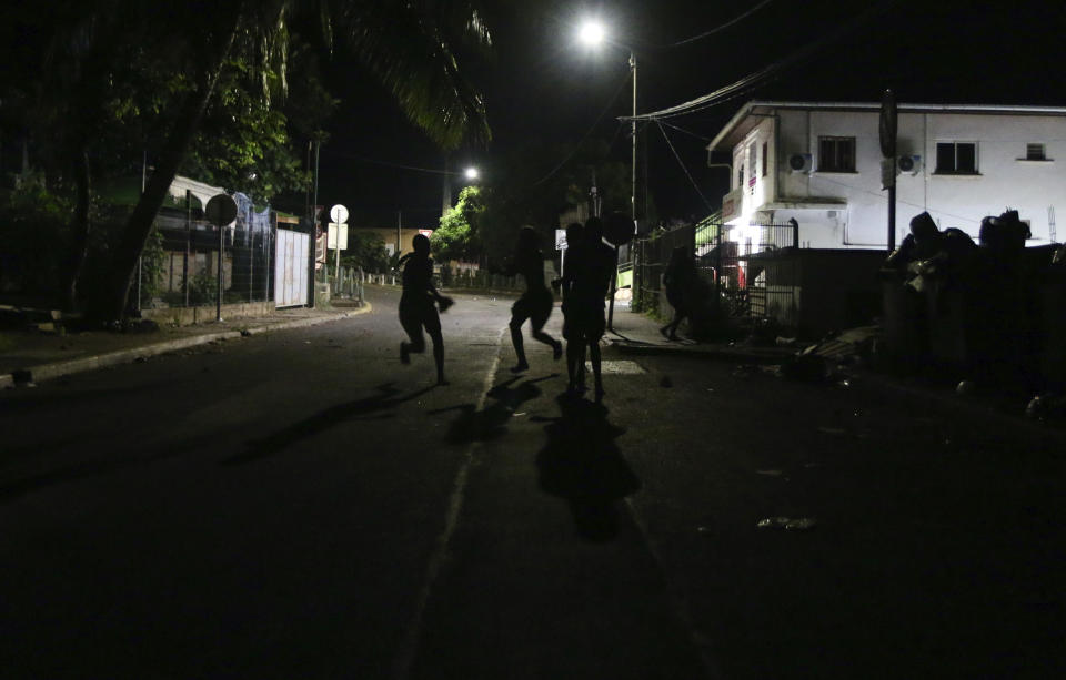 Youth run away during a scuffle with French gendarmes in Brandrele, in the French Indian Ocean territory of Mayotte, Thursday, April 27, 2023. France is facing a migration quagmire on the island territory of Mayotte off Africa’s east coast. The government sent in 2,000 troops and police to carry out mass expulsions, destroy slums and eradicate violent gangs. But the operation has become bogged down and raised concerns of abuse, aggravating tensions between local residents and immigrants from the neighboring country of Comoros. (AP Photo/Gregoire Merot)