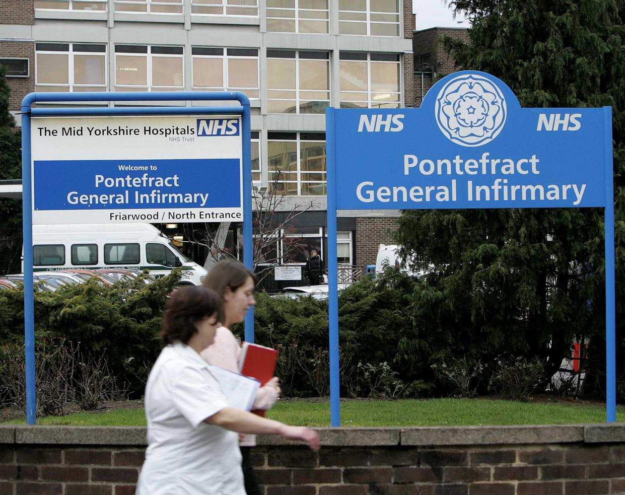 Hospital workers walk past the front of Pontefract General Infirmary, northern England, where serial killer Harold Shipman murdered three patients whilst working as a junior doctor in the 1970s, January 27, 2005. Britain's "Dr Death", family physician Harold Shipman, who systematically murdered his patients, probably killed 250 people, an inquiry announced on Thursday after ruling the number of his victims was greater than originally thought. REUTERS/Ian Hodgson  IH/ASA