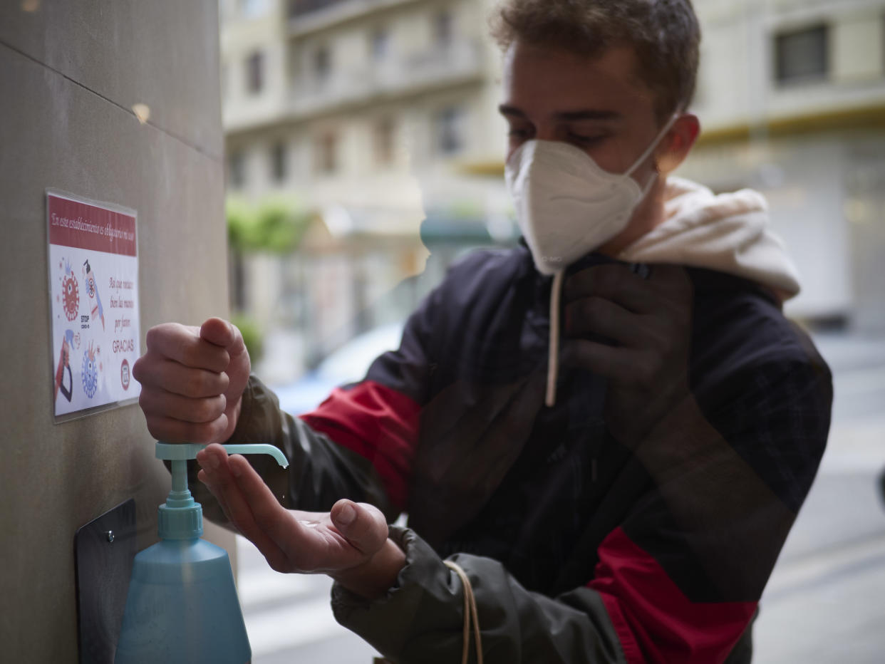 PAMPLONA, SPAIN - MAY 11: A man disinfects his hands before entering Urban Sons fashion store to protect from Covid-19 on the day all the region of Navarra passes to Phase 1 of the reduction of confinement established by the Government of Spain on May 11, 2020 in Pamplona, Spain. In the event a customer tries on a garment that they subsequently do not purchase, it must be sanitized, as well as any return of garments made by customers. (Photo by Eduardo Sanz/Europa Press via Getty Images)