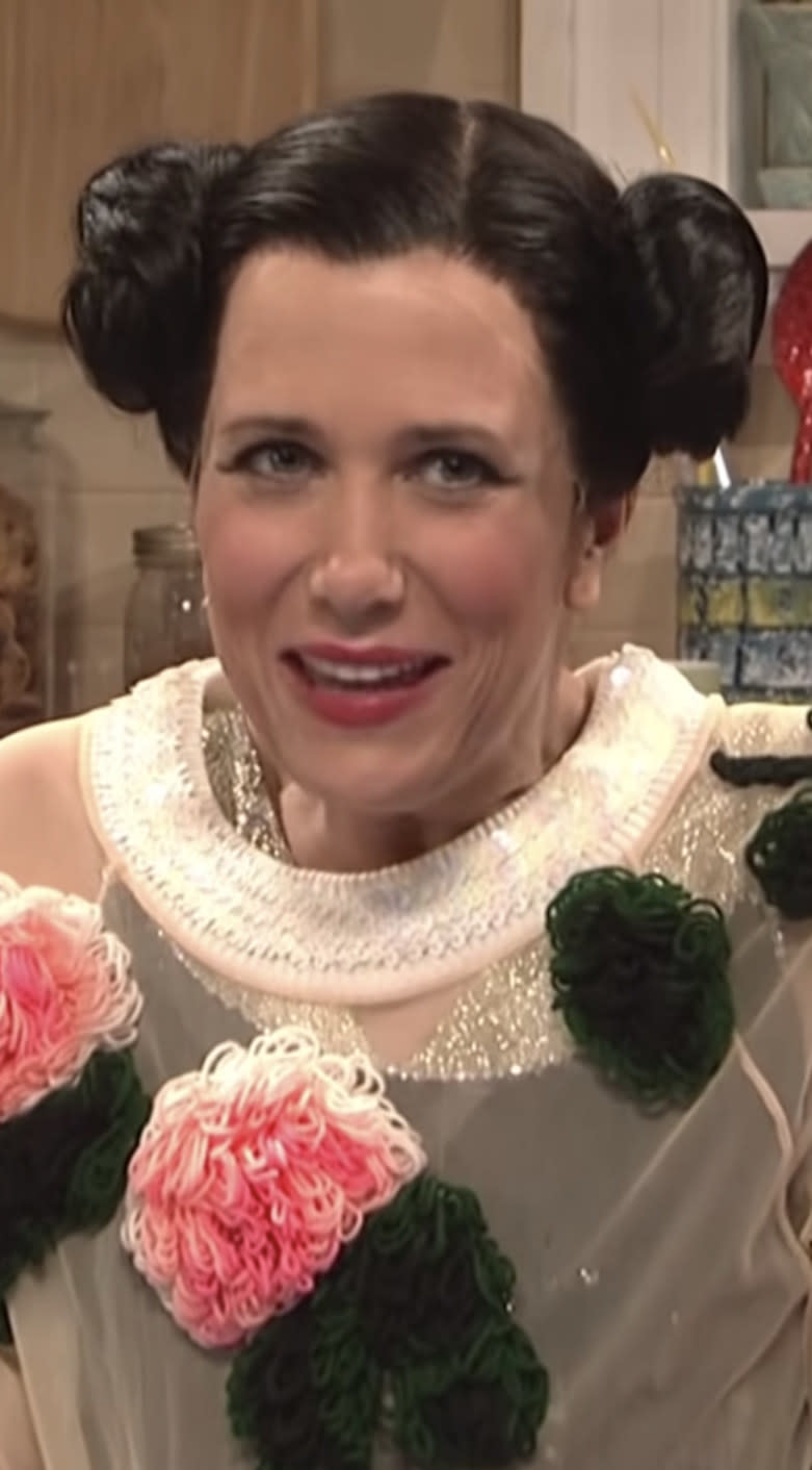 Wiig with dark hair wearing bun pig tails and a quirky outfit