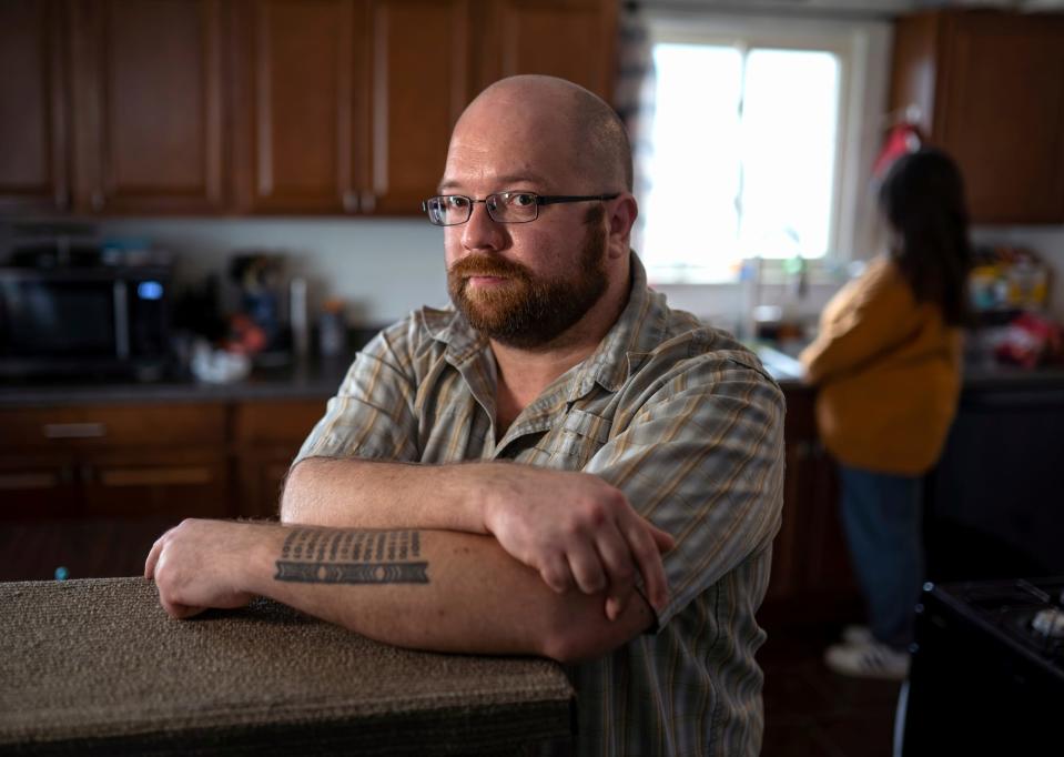 Christopher Land, of Taylor, stands near his wife, Jennifer, in the kitchen of their home on Wednesday, March 30, 2022. The Lands say they don't understand why Jennifer did not qualify for recipient rights protection under the mental health code when she was in a hospital emergency room.