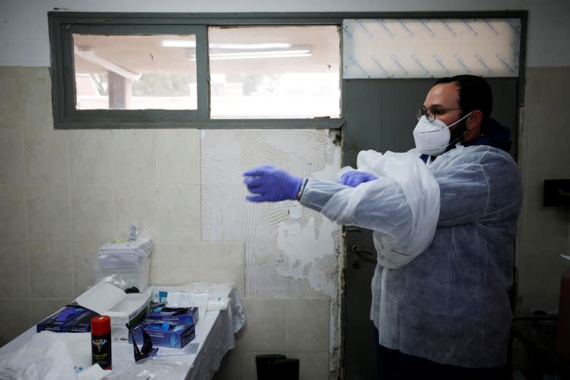 Yakov Kurtz, who works for Chevra Kadisha, the main group overseeing Jewish burials in Israel, adjusts his protective gear at a special centre that prepares bodies of Jews who died from the coronavirus disease (COVID-19) in Tel Aviv