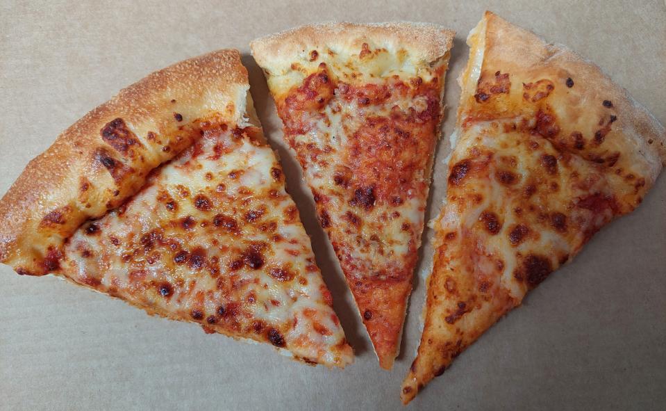 Slices of pizza from Pizza Hut, Domino's, and Papa John's displayed next to each other in a pizza box