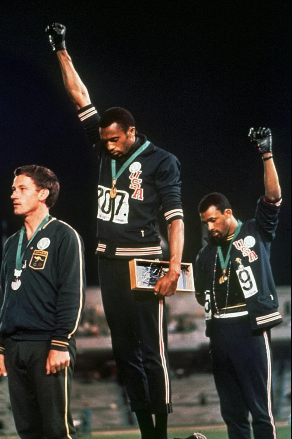 Tommie Smith and John Carlos raise their gloved fists after Smith received the gold and Carlos the bronze for the 200 meter run at the Summer Olympic Games in Mexico City. - Credit: AP Image