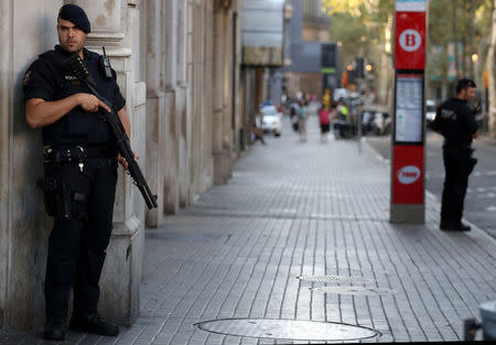 Armed Catalan Mossos d'esquadra officers stand guard at Las Ramblas street where a van crashed into pedestrians in Barcelona, Spain, August 18, 2017. REUTERS/Sergio Perez